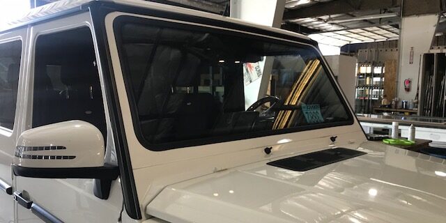 A white jeep is parked in a building.