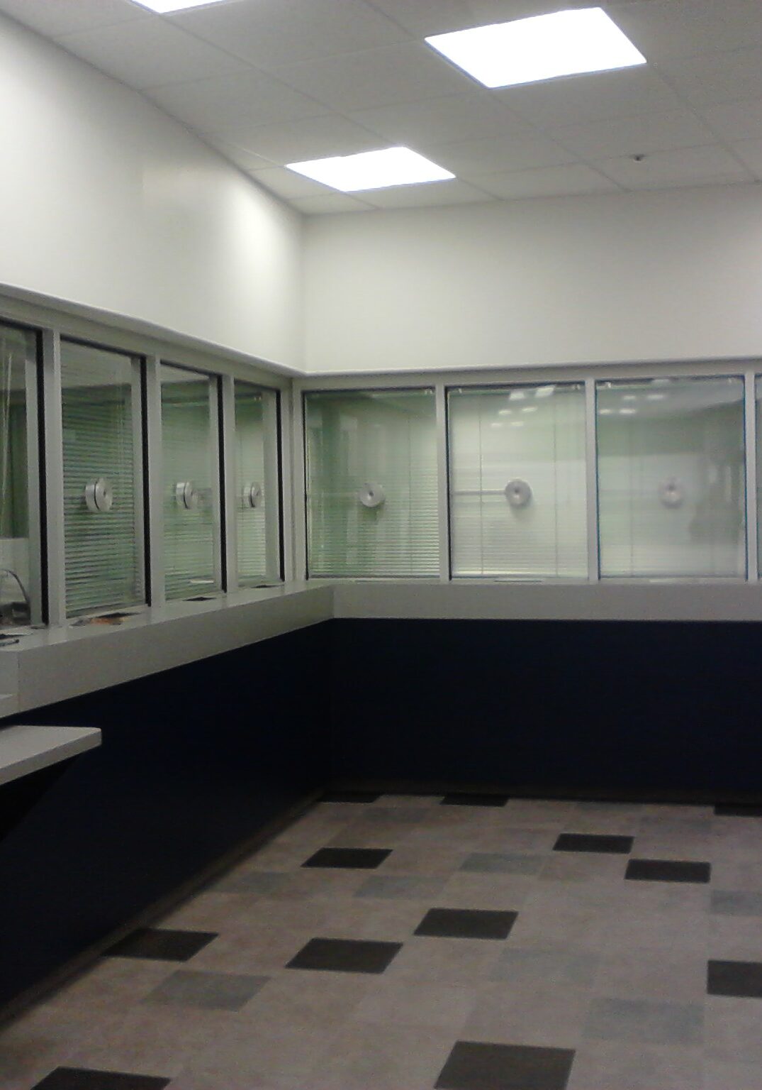 A room with many glass walls and black cabinets.